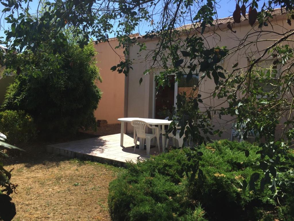 une table et une chaise blanches devant une maison dans l'établissement Maison Neuve à Longeville-sur-Mer : Confort et Tranquillité Proche Plage - FR-1-336-117, à Longeville-sur-Mer