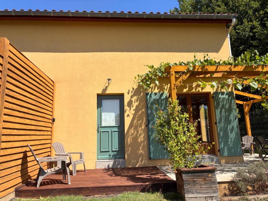 une terrasse en bois avec une table et des chaises sur une maison dans l'établissement Au doux paillis Sorgue, au Thor