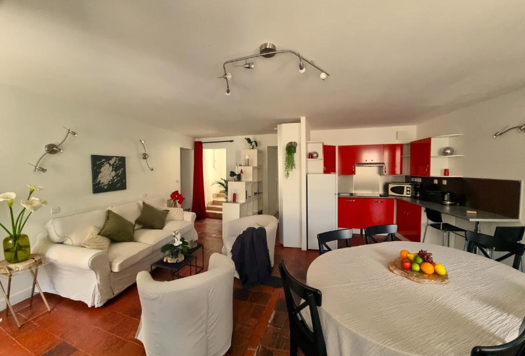 a living room with red cabinets and a white couch at La Signature - Appt 70m² pour 6 voyageurs in Bayeux