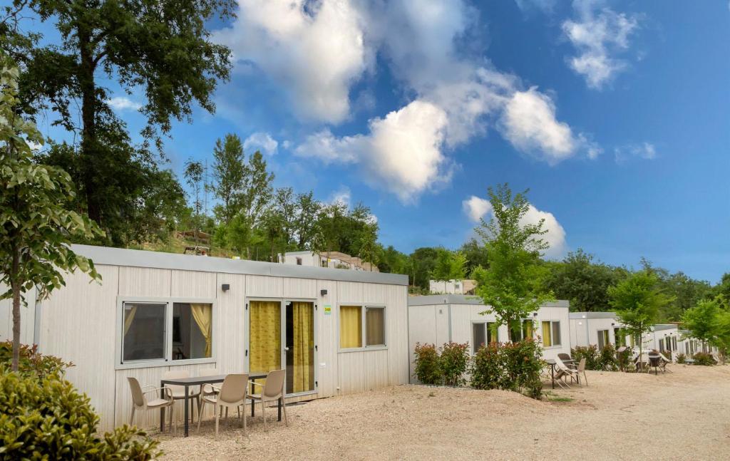 a white building with a table and chairs at hu Firenze Certosa camping in town in Impruneta
