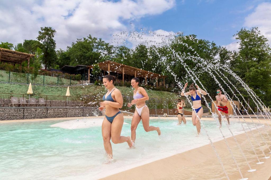 a group of people in the water at a swimming pool at hu Firenze Certosa camping in town in Impruneta