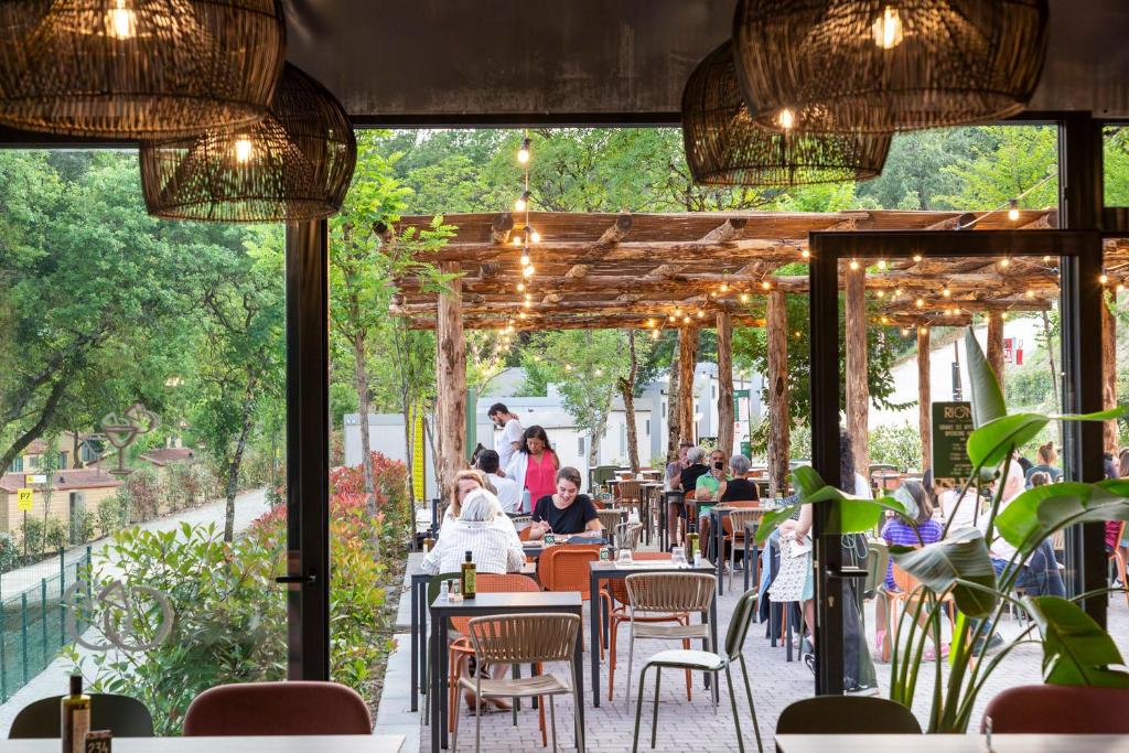 a restaurant with tables and chairs and people sitting at hu Firenze Certosa camping in town in Impruneta