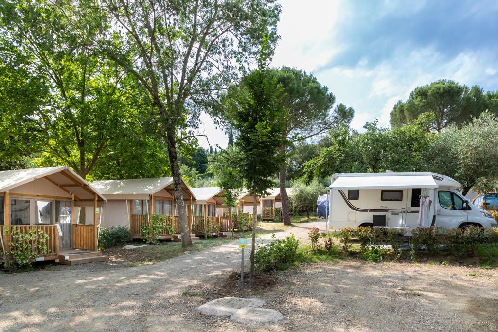 a row of mobile homes with a camper and a van at hu Firenze Certosa camping in town in Impruneta