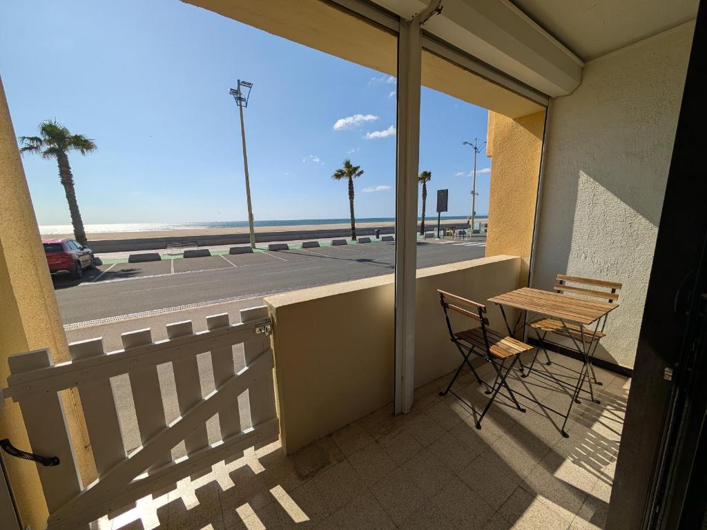un balcon avec une table et des chaises et une vue sur l'océan dans l'établissement Appartement T2 Front de Mer avec Balcon et Parking – Confort et Activités à Proximité - FR-1-797-37, à Port-la-Nouvelle