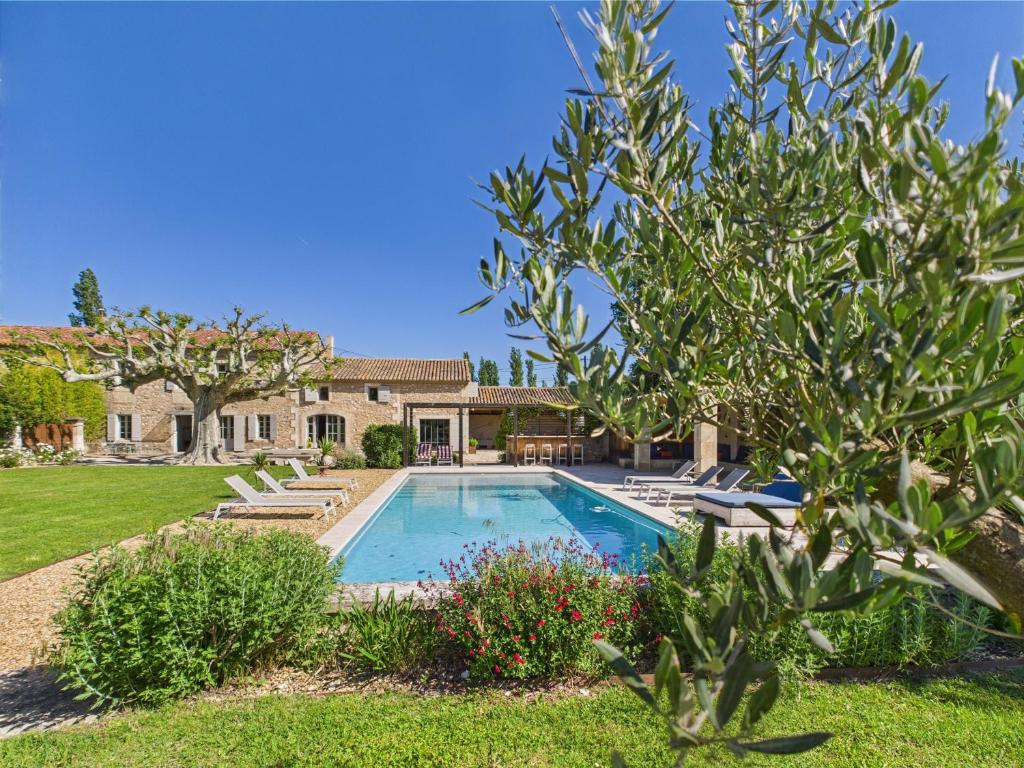 une maison avec une piscine dans une cour dans l'établissement Magnifique Mas Provençal avec Piscine à Eygalières - 19 Couchages, 8 Chambres, Billard, et Plus ! - FR-1-599-3, à Eygalières