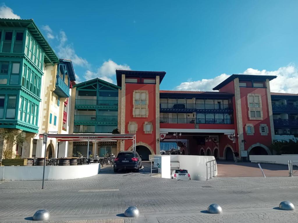 un groupe de bâtiments avec une voiture garée dans un parking dans l'établissement Spacieux T2 à Hendaye avec parking à deux pas de la plage - FR-1-239-794, à Hendaye