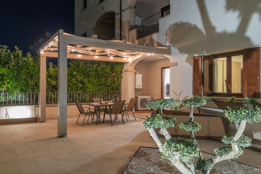 a patio with a table and chairs and a building at Colino APT in Olbia