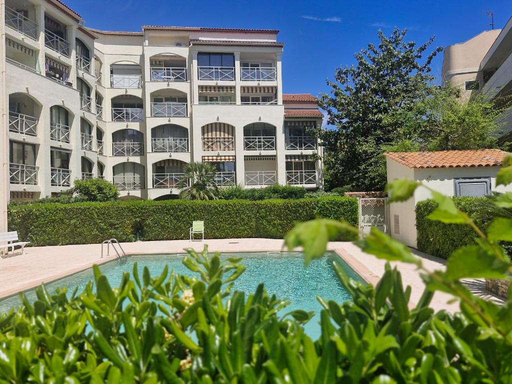 une piscine devant un immeuble dans l'établissement Studio avec Cabine, Piscine, Parking Privé, Proche Plages à Sainte-Maxime - FR-1-780-7, à Sainte-Maxime