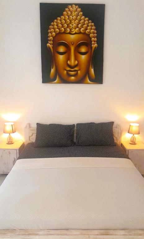 a bedroom with a bed with a gold mask on the wall at Wombat's B&B in Gili Trawangan