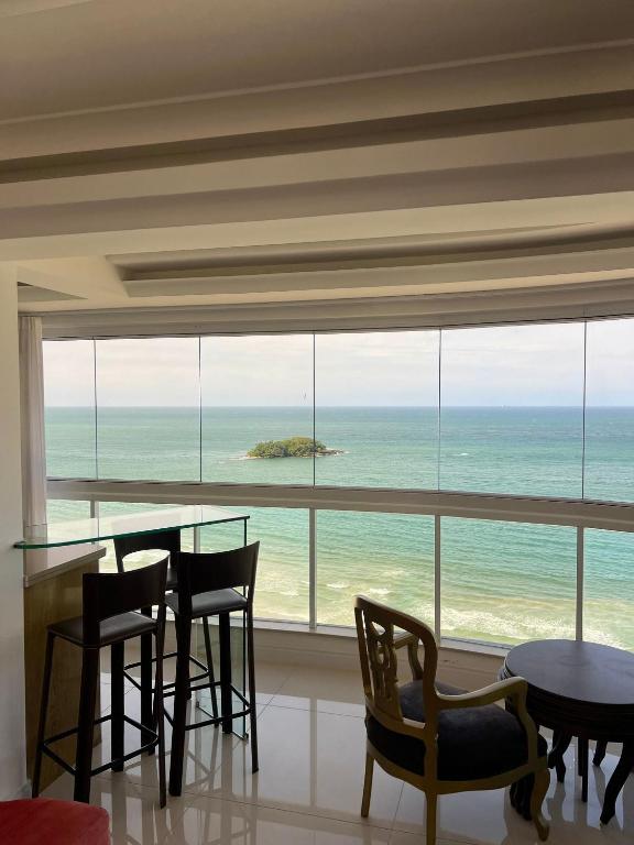 a dining room with a view of the ocean at 3 Dorm. Frente Mar com Churrasqueria #16 in Balneário Camboriú