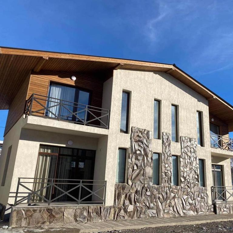 una casa con facciata in pietra e balcone di Mountain Cottage In Bakuriani a Bakuriani