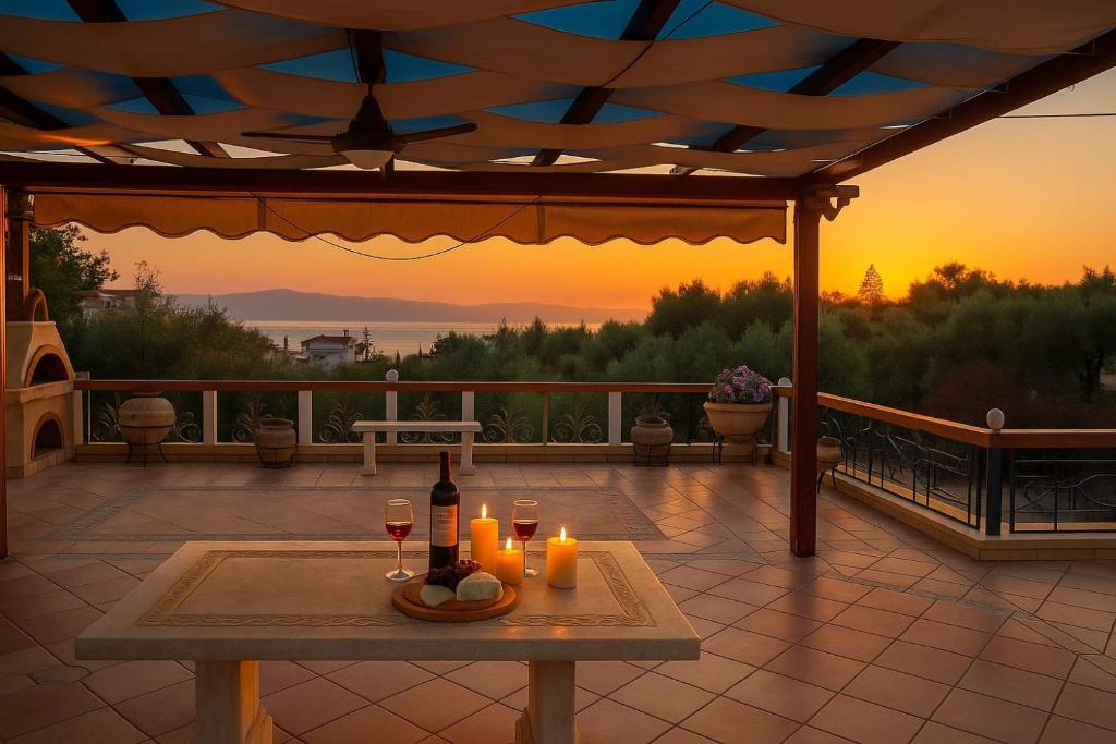 stół z dwoma kieliszkami wina na patio w obiekcie Bianca Maisonette - Panoramic Golden View w Kalamácie