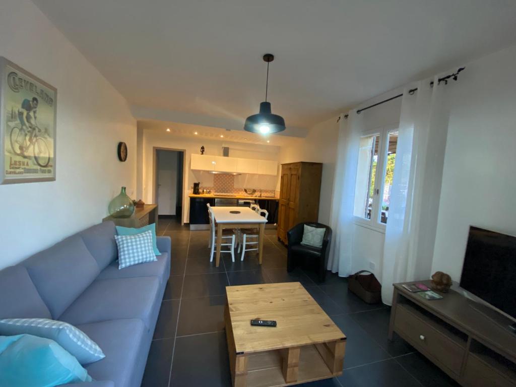 un salon avec un canapé bleu et une table dans l'établissement Résidence IN&OUT, à Loriol-du-Comtat