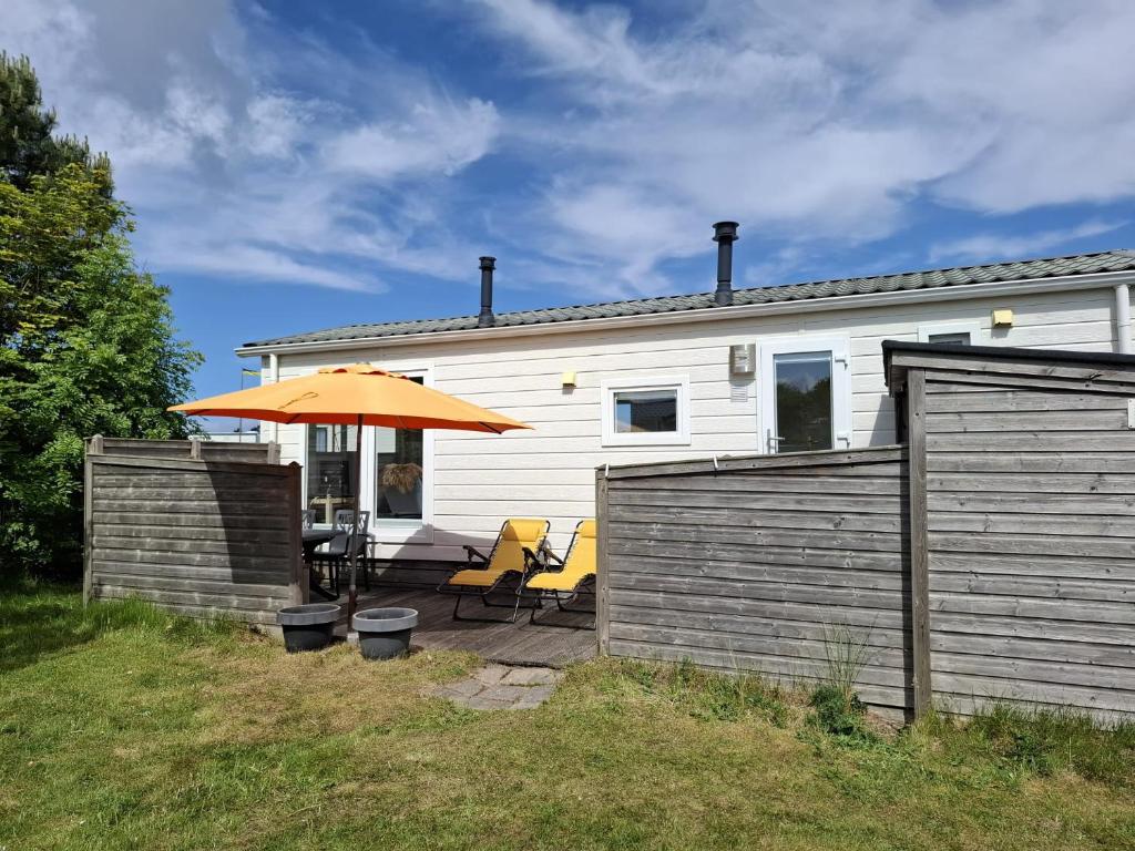 a house with an orange umbrella and a patio at Elora in Ballum
