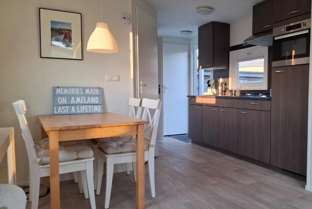 a kitchen with a wooden table and chairs in a room at Elora in Ballum