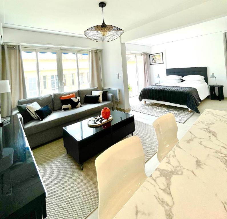 un salon avec un canapé et un lit dans l'établissement Suite élégante et moderne Cannes centre, à Cannes