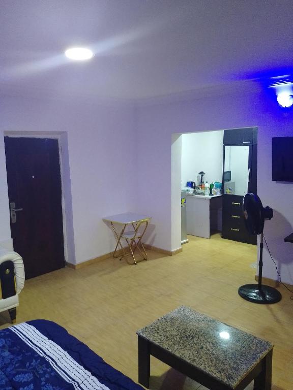 a room with a bed and a table and a kitchen at Peace in Lekki