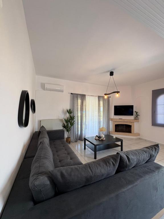 a living room with a large couch and a table at Irène House in Egina