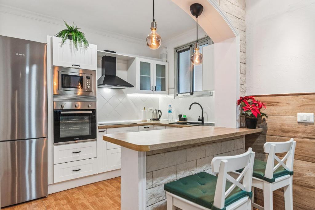 VallesecoにあるHome2Book Valleseco Mountain Views, BBQ & Jacuzziの白いキャビネットとステンレス製の冷蔵庫を備えたキッチン