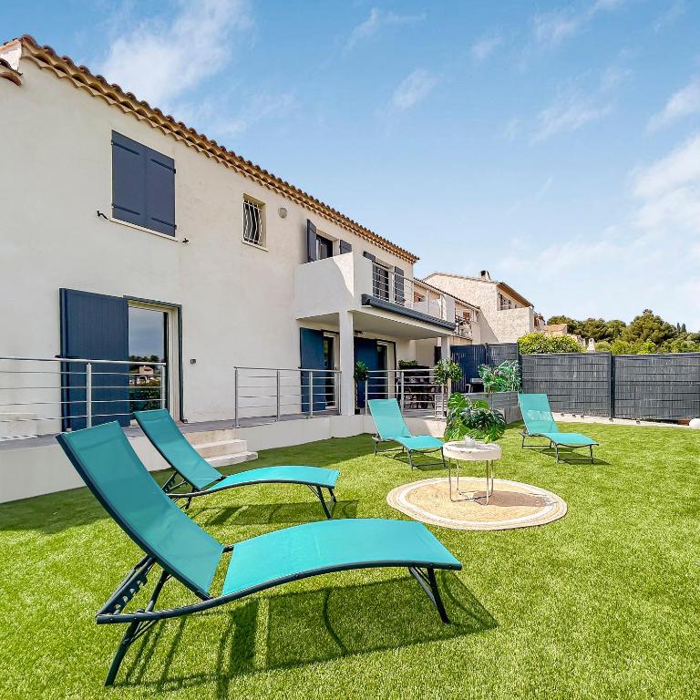 une cour avec des chaises et une table ainsi qu'une maison dans l'établissement Havre de paix avec terrasse, à La Gaude