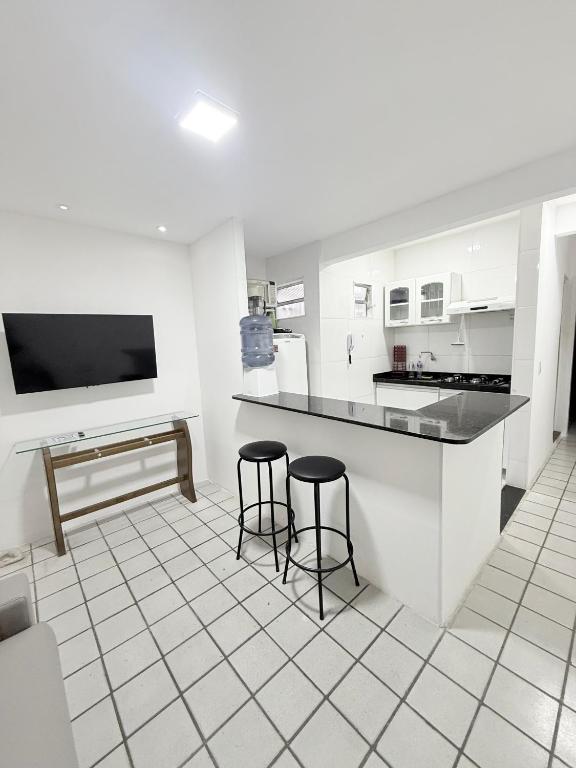 a kitchen with two bar stools and a counter at APARTAMENTO NO MELHOR DE BOA VIAGEM in Recife
