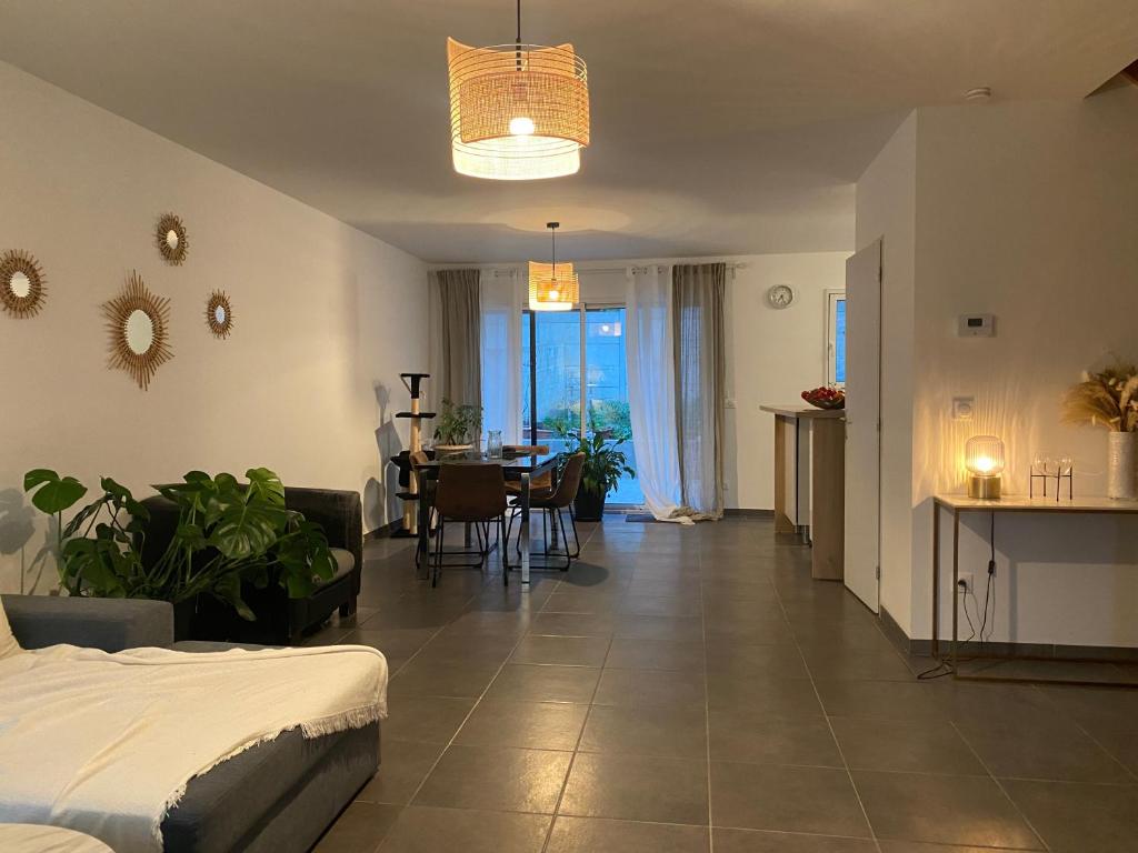 a living room with a bed and a dining room at Maison familiale proche de paris in Bagneux