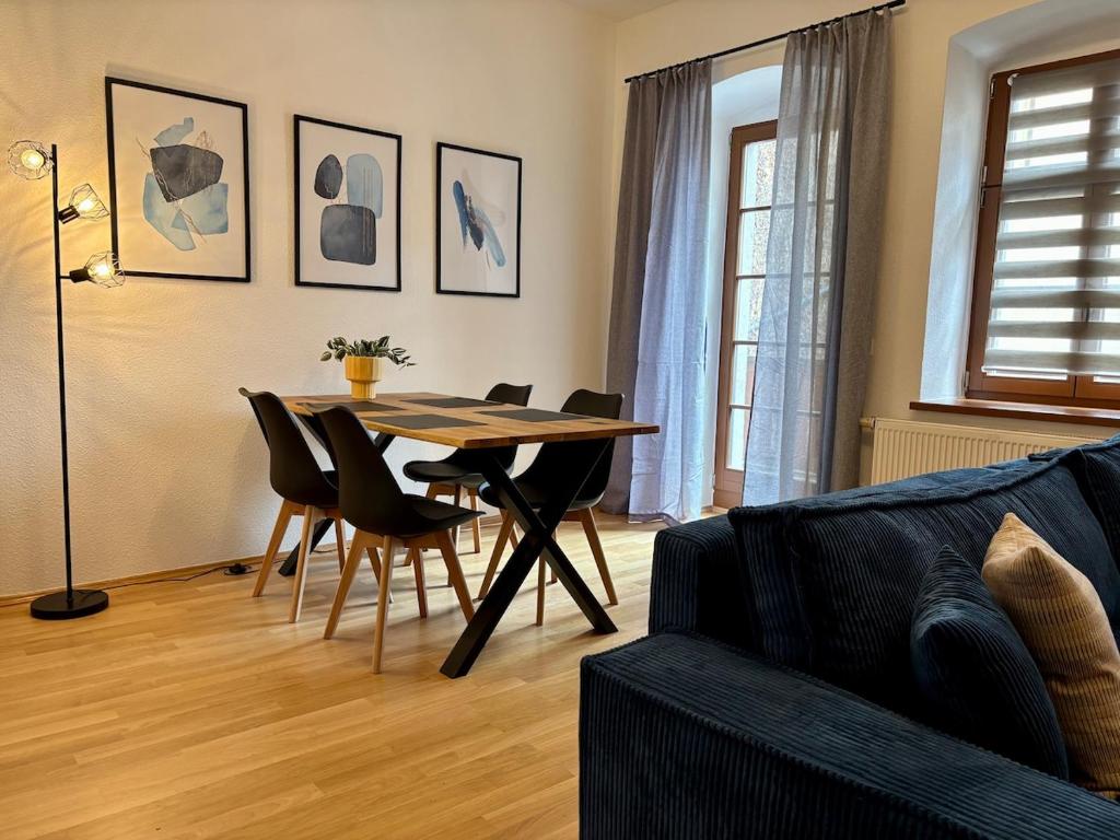 a living room with a dining room table and chairs at Gassentraum NEU mit Balkon in Pirna