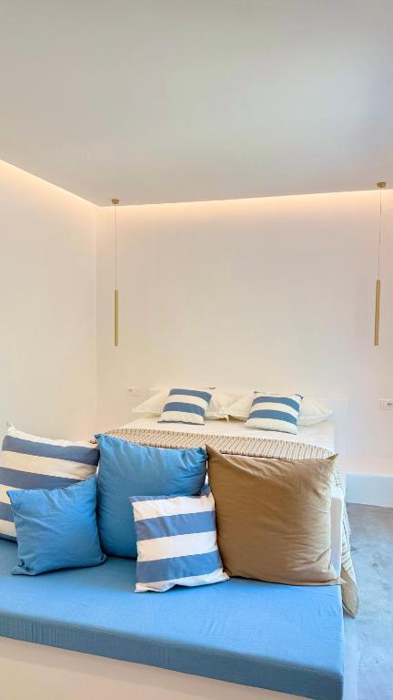 a bed with blue pillows in a room at Rida Village Ksamil Island in Ksamil