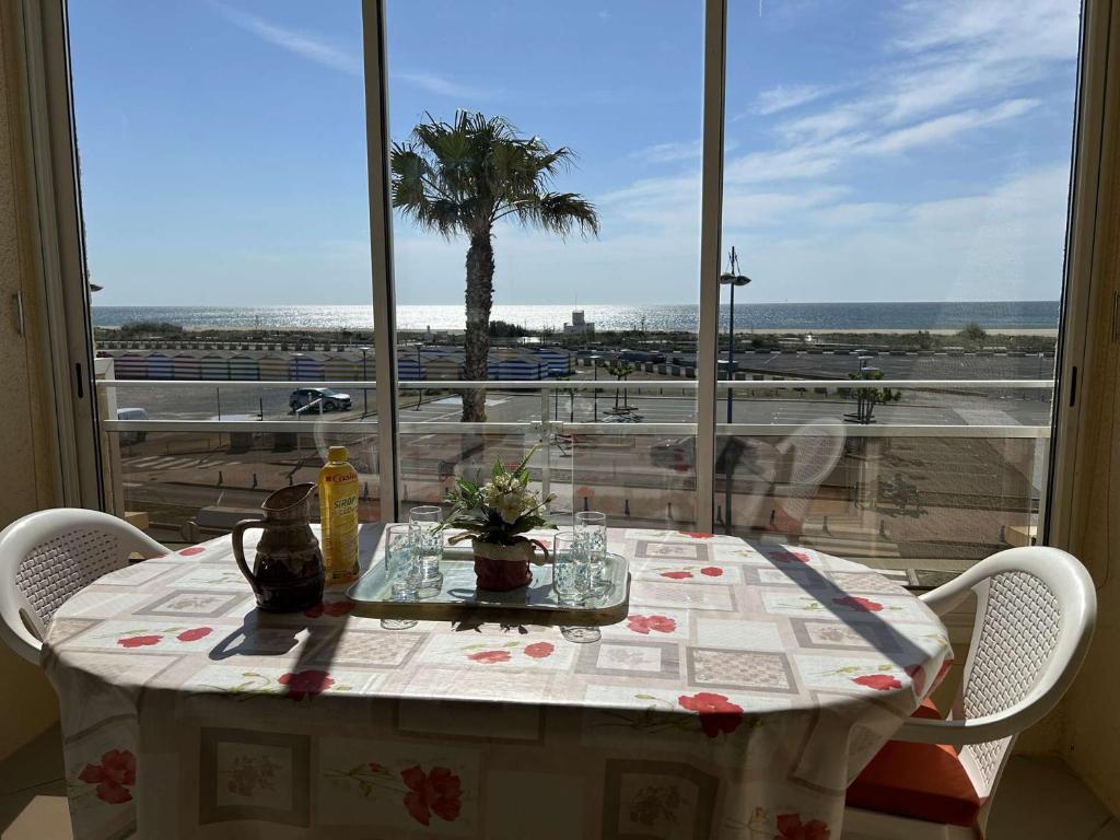 d'une table avec vue sur la plage depuis une fenêtre. dans l'établissement SP150-015 Appartement studio mezzanine 3 couchages SAINT PIERRE LA MER, à Saint Pierre La Mer