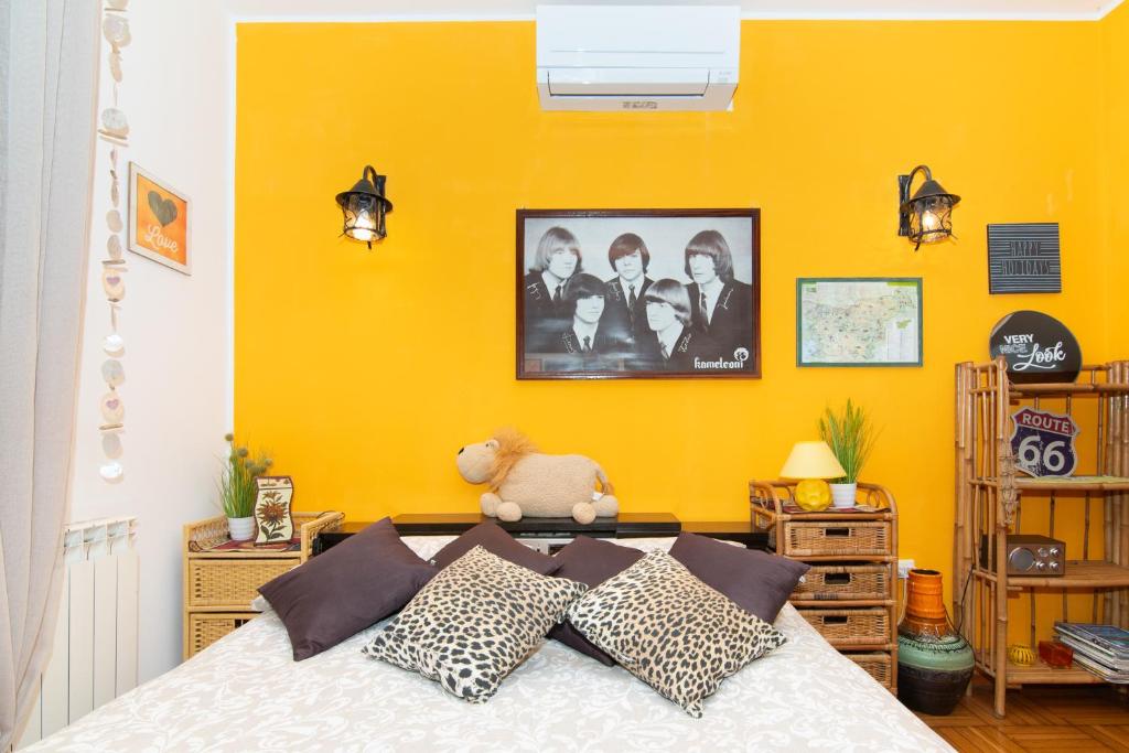 a bedroom with a bed with a yellow wall at Apartments Baredi in Izola