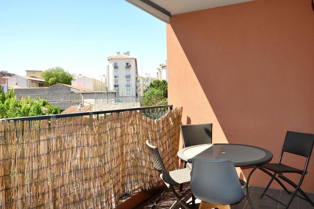un patio avec une table et des chaises sur un balcon dans l'établissement Balcony apartment in the heart of Marseille, à Marseille