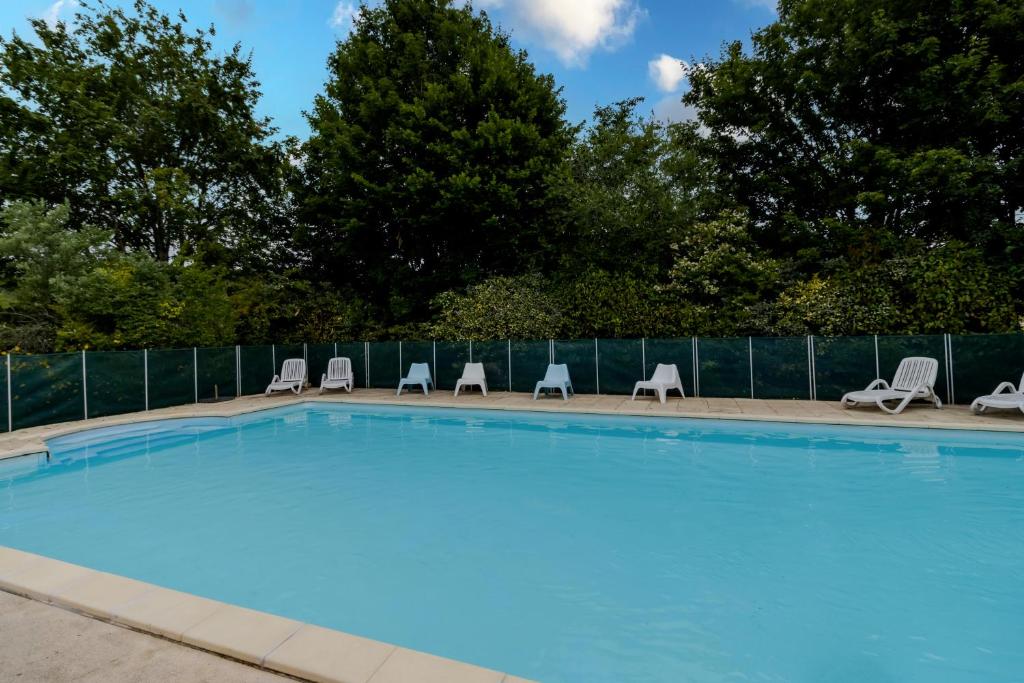 une grande piscine avec des chaises et une clôture dans l'établissement Maison La Barge, à La Forge-dʼAns