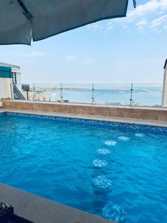 a blue swimming pool with a view of the ocean at Dahab Panorama Villa Private Pool in Dahab