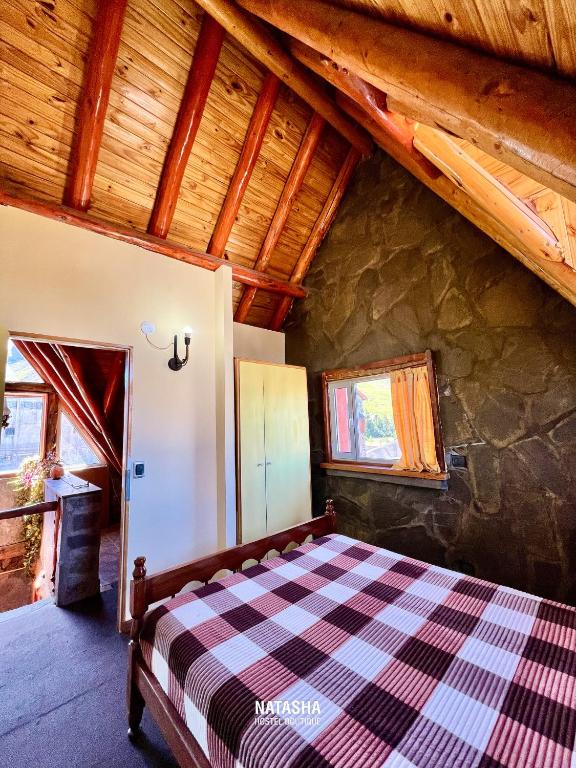 1 dormitorio con 1 cama en una casa en Natasha Hostel Boutique, en Caviahue