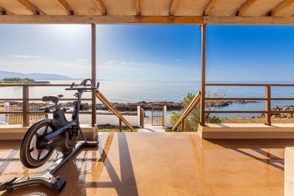 a bike on a stand in front of the ocean at Villa Zoi in Sissi