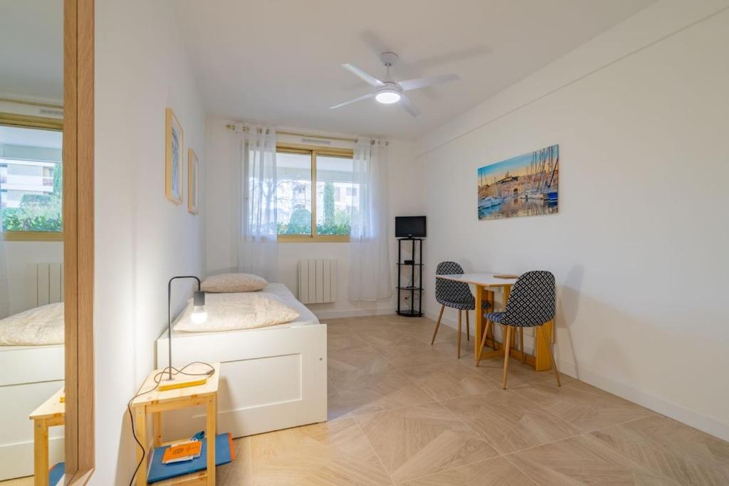 une chambre avec un lit, une table et des chaises dans l'établissement Les Roches d'Or, nice studio, à Marseille