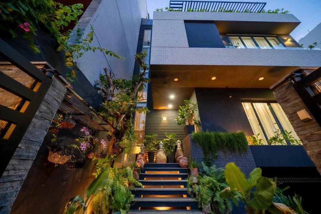 an image of a house with plants on the stairs at Sila Anila 7BRs Pool Villa My Khe Beach Da Nang in Da Nang