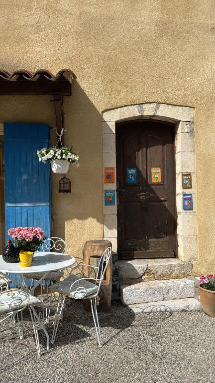 une table et des chaises devant un bâtiment avec une porte dans l'établissement Ferme de Sejour Rebuffel, à La Roque-Esclapon