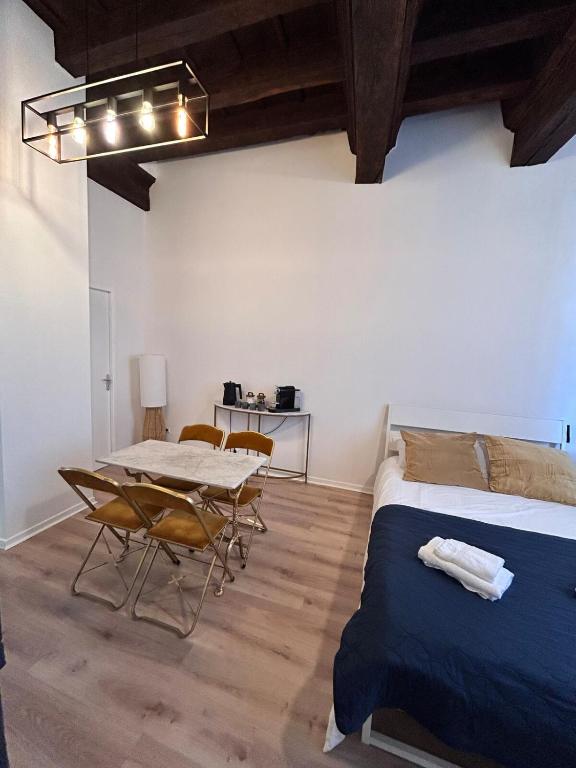 une chambre avec un lit, une table et des chaises dans l'établissement Appartement - Albi Cathédrale, à Albi