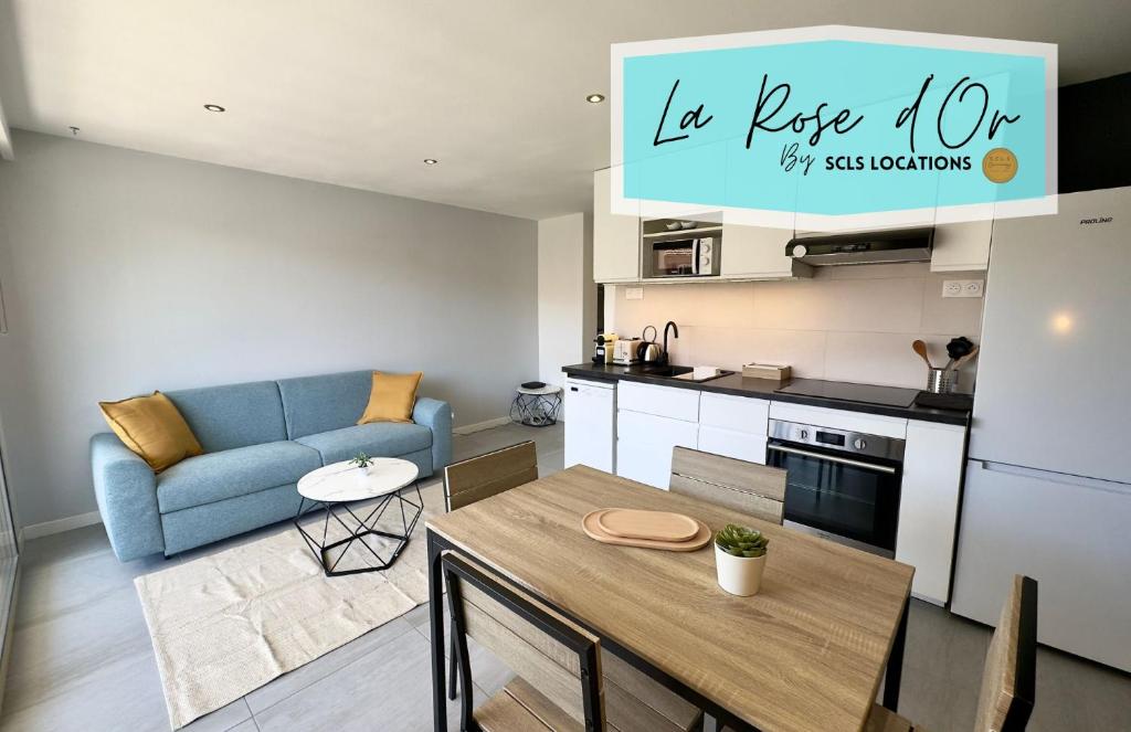 Il comprend une cuisine et un salon avec une table et un canapé bleu. dans l'établissement La Rose d'Or - SCLS Locations, au Cannet