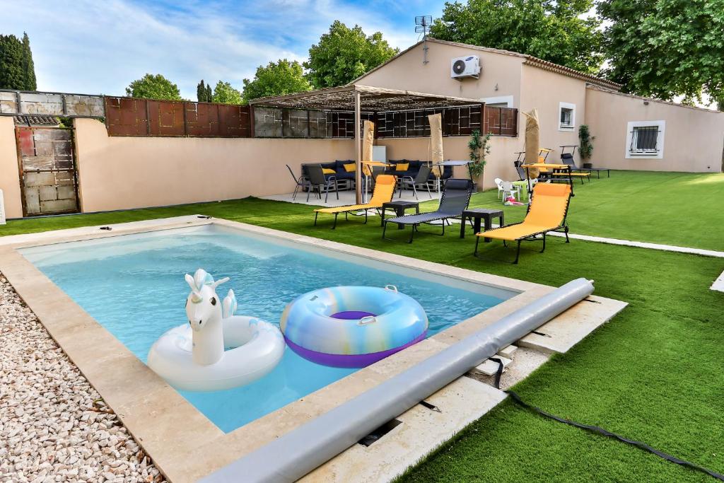 une piscine avec un cheval jouet sur un flotteur dans une cour dans l'établissement La Maison du Bonheur !, à Graveson