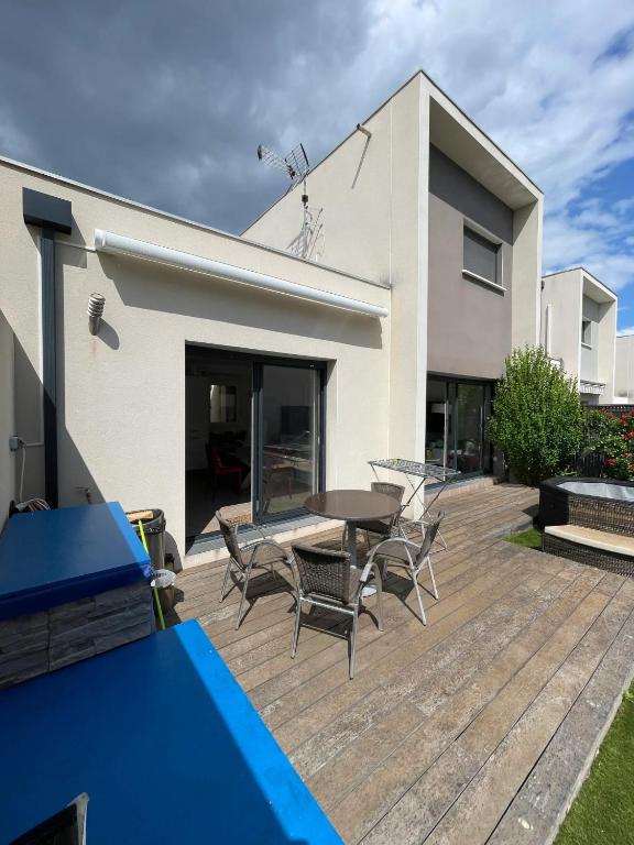 un patio avec une table et des chaises devant une maison dans l'établissement Maison familiale avec piscine à Juvignac, 90 m², 6 pers., à Juvignac