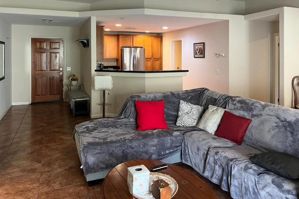 a living room with a gray couch with red pillows at Desert Hot Springs Cozy Retreat in Desert Hot Springs