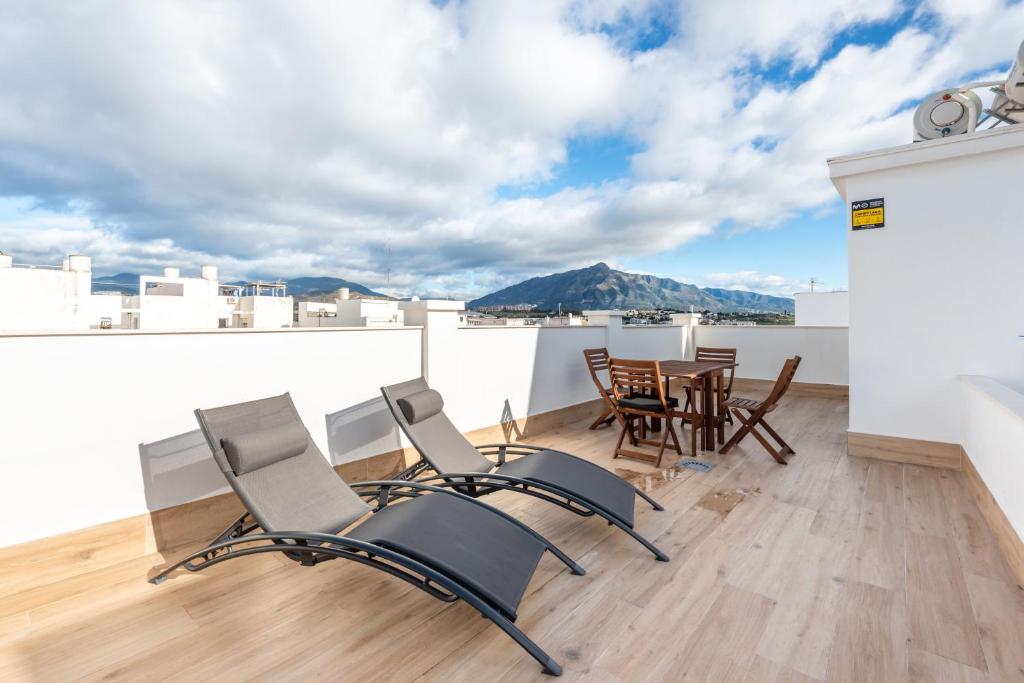 a room with chairs and a table on a roof at Moderno Apartamento in Marbella