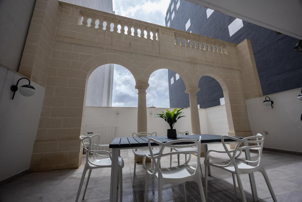 a dining room with a table and chairs and a bridge at GuestHost - Sliema Breeze & Patio Comfort in Sliema