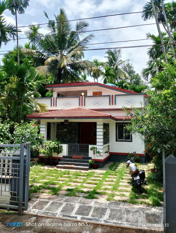 a house with a motorcycle parked in front of it at 'Ananda' Homestay in Murud in Dande