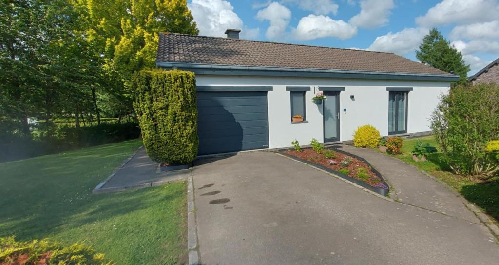 a white house with a garage at La Casa Bianca in Lierneux