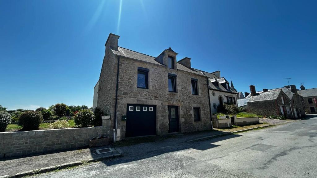 un vieux bâtiment en briques avec une porte dans une rue dans l'établissement Maison Bretonne 5 chambres proche de la mer, à Saint-Potan