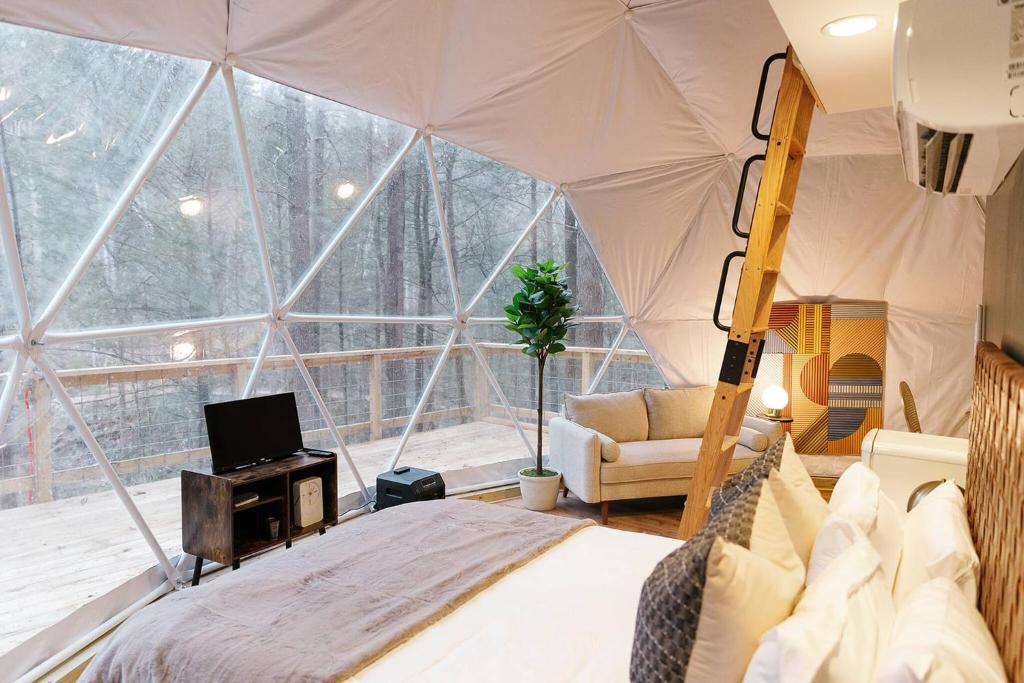 ein Schlafzimmer mit einem Zelt mit einem Bett und einem Fernseher in der Unterkunft "The Perch" Elevated Woodsy Modern Stay w/ Hot Tub in High Falls