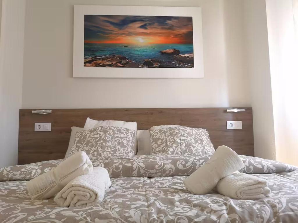 En eller flere senge i et værelse på Suite Aeropuerto Madrid Wanda 449